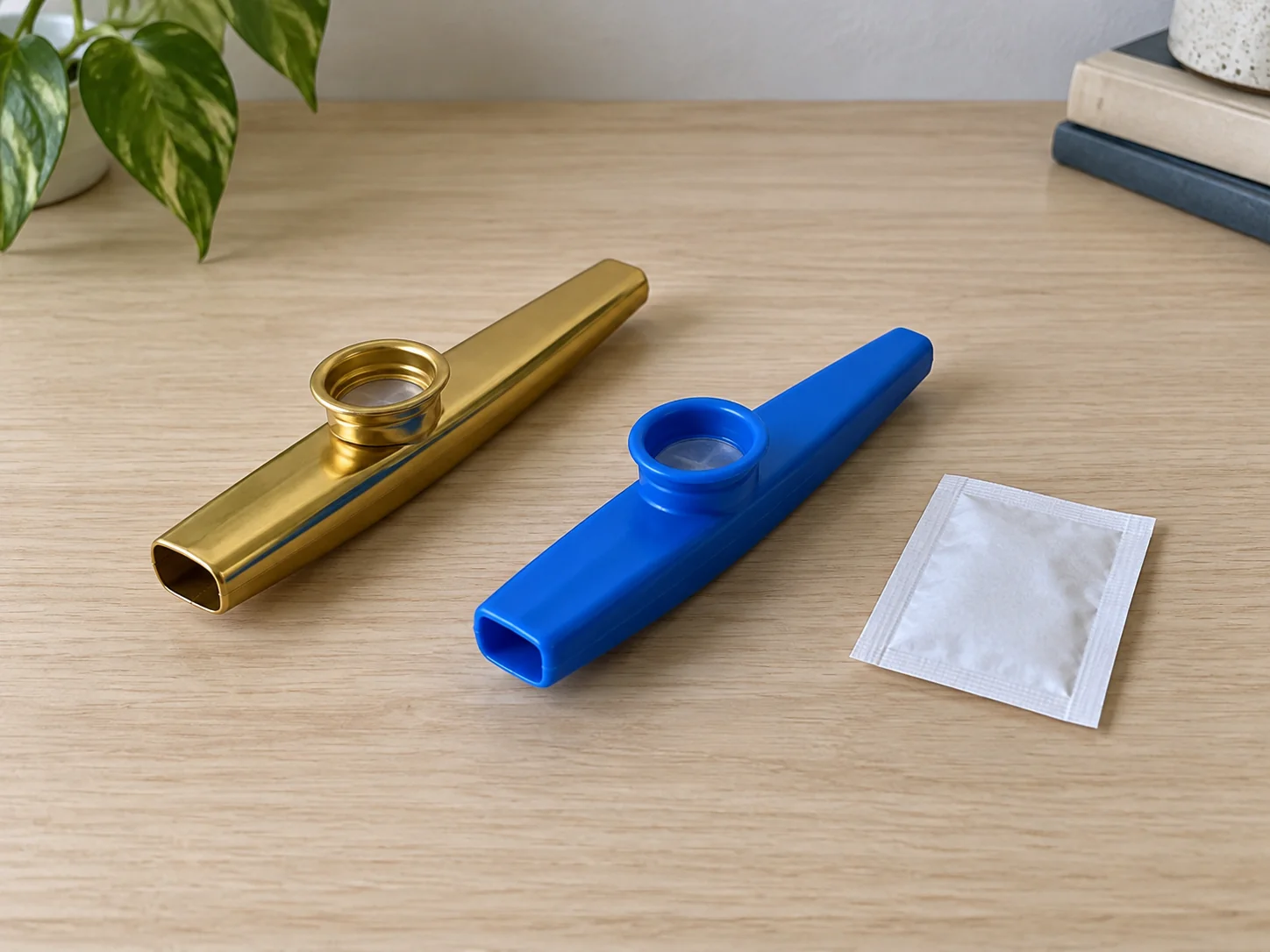 Kazoo sound concept with two complete generic inactive kazoos and a whole closed blank packet; no exact retail model or replacement fitting is demonstrated.