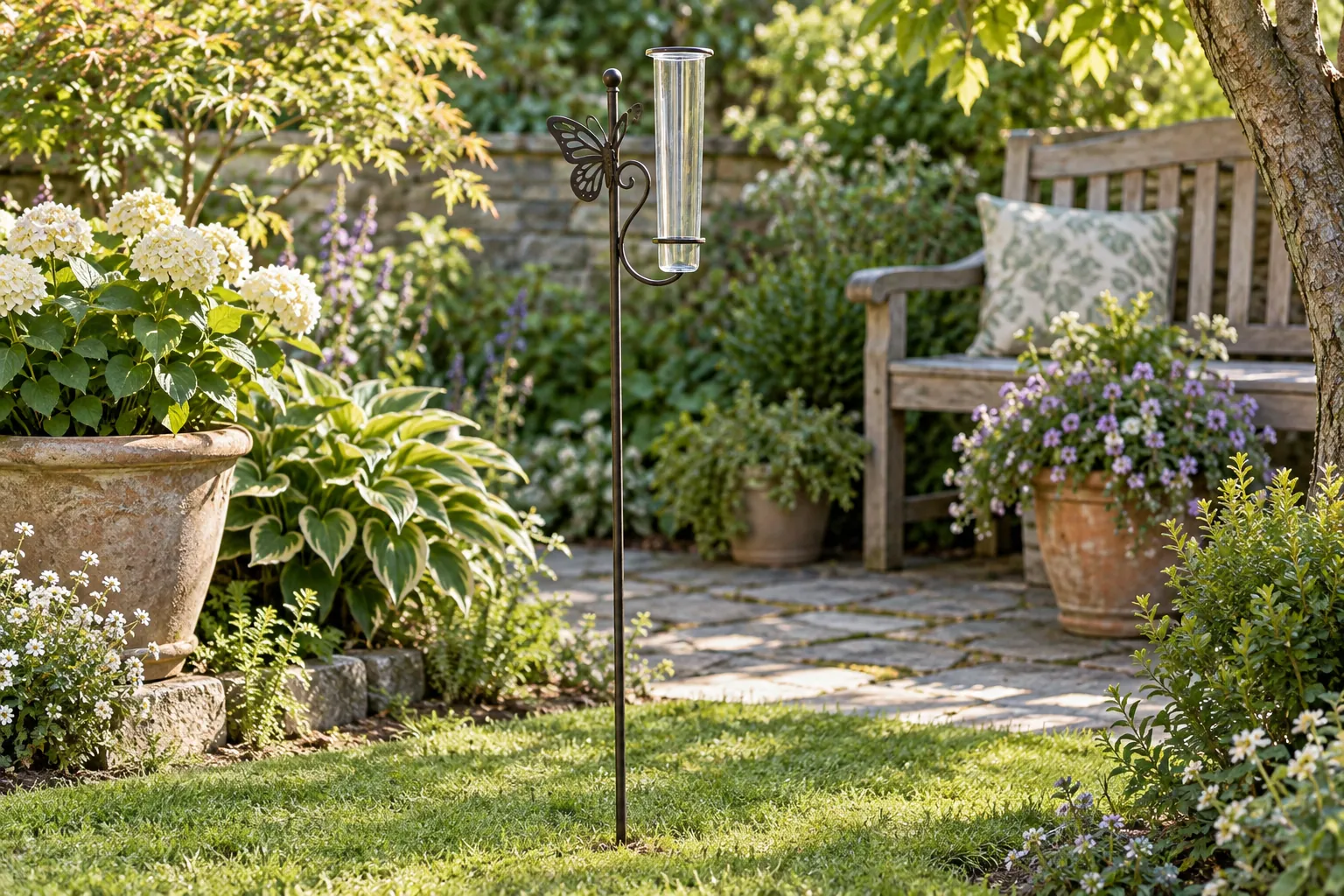 Rain gauge garden stakes concept with a whole generic butterfly ornament and empty glass tube in a leafy garden beside a wooden bench